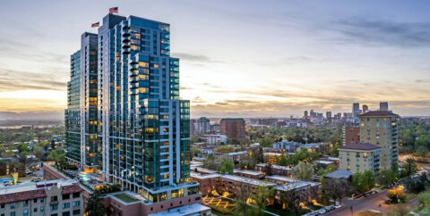 Country Club Towers apartments with modern architecture and clean glass construction with Denver in the distance.