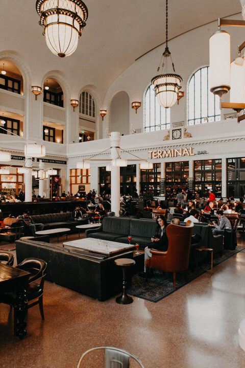 Terminal at Union Station bustling with people sitting together working, drinking, and relaxing.