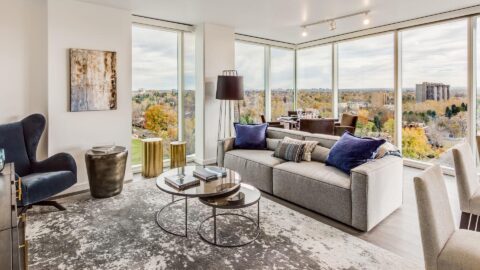 Comfortable modern living room with plush seating areas and large windows overlooking Denver.